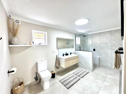 a bathroom with a toilet and a sink and a shower at Adrift Guesthouse in St Francis Bay