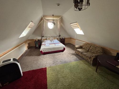 a bedroom with a bed and a couch in a room at Hotel Pałacyk Konin in Konin