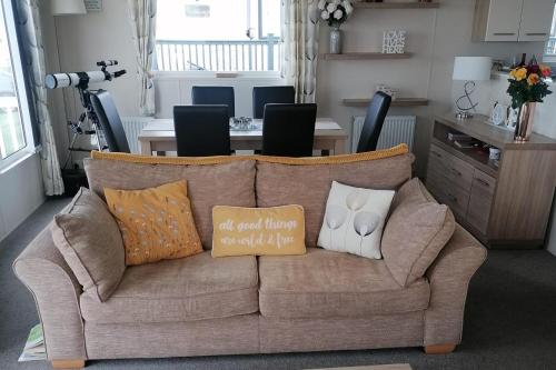 a couch with pillows on it in a living room at 3-Bed Lodge with SeaView-Fireplace-Garden-FreeP in Eyemouth