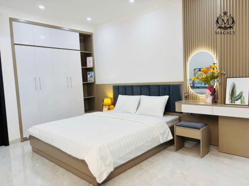 a bedroom with a large bed and a mirror at Magaly Apartment & Hotel in Hai Phong