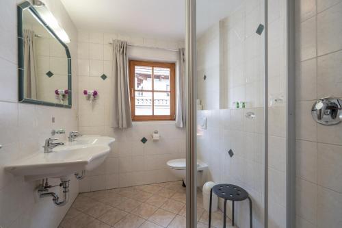 a bathroom with a sink and a toilet and a shower at Beim Nuihausa in Reit im Winkl