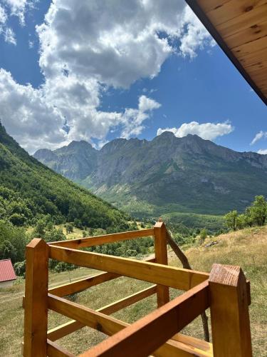 a wooden fence with mountains in the background at A&R cottage in Vusanje
