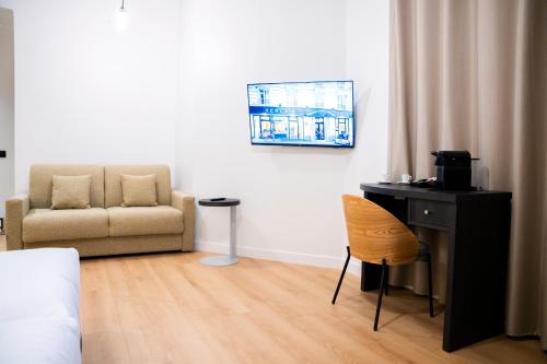 a bedroom with a desk and a couch and a chair at Verlain in Paris
