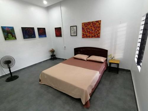 a bedroom with a bed and paintings on the wall at Orange Beach House in Phú Quí (2)