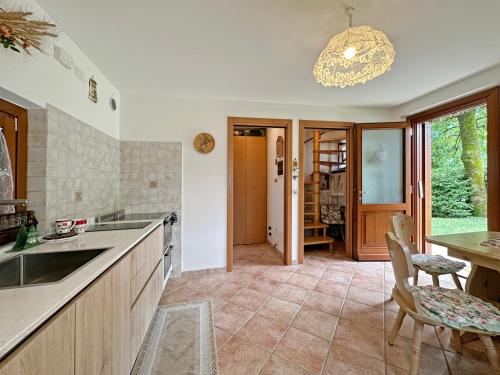 a kitchen with a sink and a table and chairs at BBkey la Villetta Garden in Arta Terme