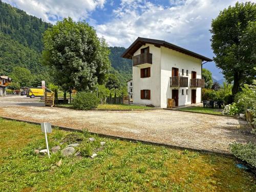 a small house on a gravel road next to a field at BBkey la Villetta Garden in Arta Terme