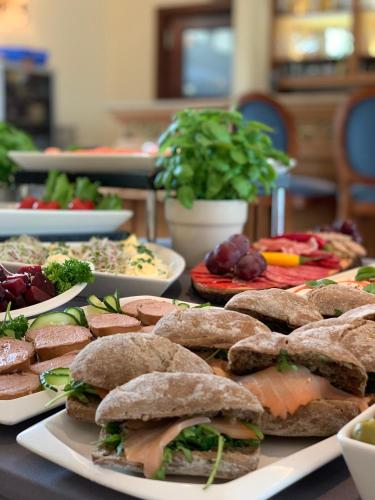 a table topped with plates of sandwiches and vegetables at Apartamenty Browar Luxury Old Town Poznań 24h in Poznań