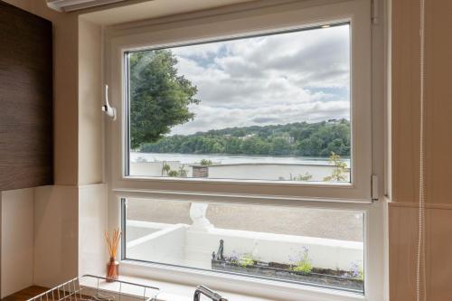 a window in a kitchen with a view of a lake at Dolfor in Menai Bridge