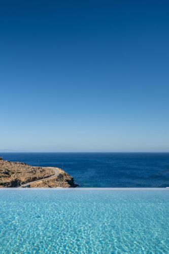 a body of water with a road in the distance at The Royal Blue Andros in Batsi