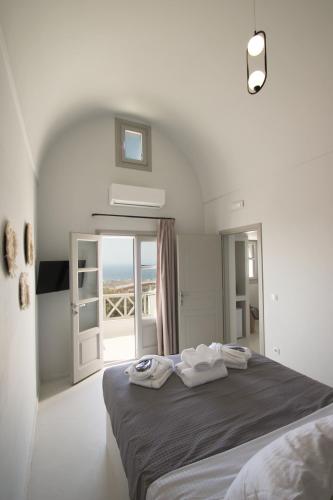 a bedroom with a bed with towels on it at Airy Suites Santorini in Oia