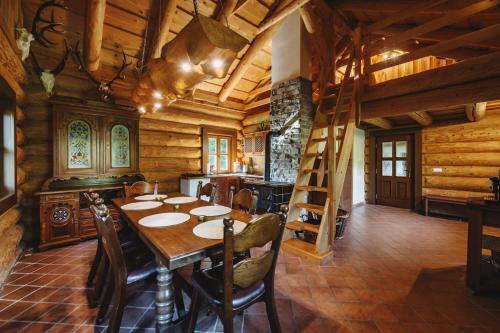 a dining room with a table and a ladder at Šumavská Vlčice - Rybářský srub in Strážný