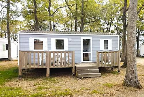 a tiny house with a porch and a tree at MH First 6pers 30min PuyduFou HellFest in La Boissière-de-Montaigu