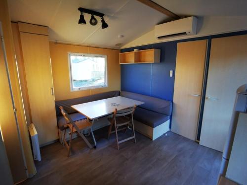 Cette petite chambre comprend une table et des chaises. dans l'établissement MH First 6pers 30min PuyduFou HellFest 120FD, à La Boissière-de-Montaigu