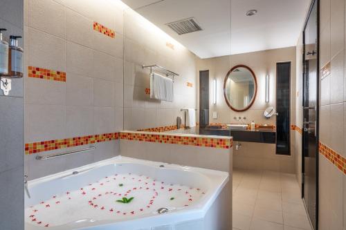 un bagno con una vasca con un fiore sopra di Hulhule Island Hotel- Private Beach Access & Airport Pick-up and Drop a Città di Malé