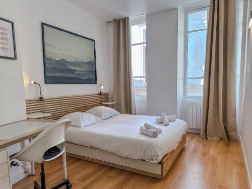 una camera da letto con scrivania e un letto con asciugamani di Le Palais - Hypercentre a Grenoble