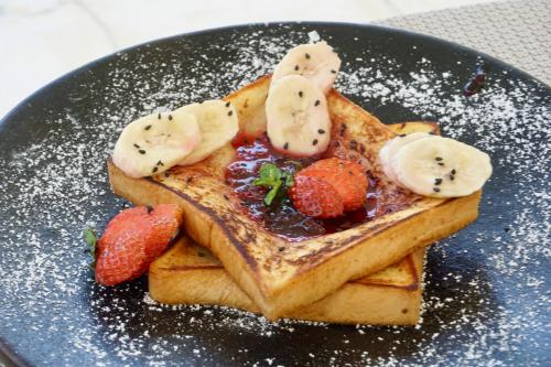 Un plato de waffles con fresas y plátanos encima. en Djati Retreat Pandawa, en Nusa Dua
