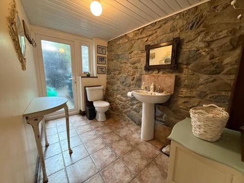 a stone bathroom with a sink and a toilet at Elegant 4-Bed Pet-Friendly Retreat in Snowdonia in Conwy