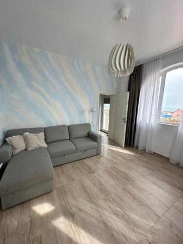a living room with a couch and a painting on the wall at Halta Pescăruş Accommodation in Douăzeci şi Trei August
