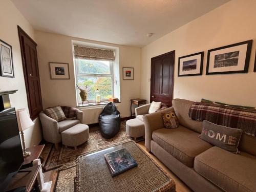 a living room with a couch and chairs and a tv at Elegant 4-Bed Pet-Friendly Retreat in Snowdonia in Conwy