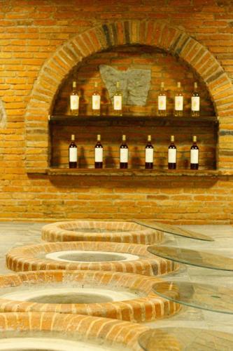a brick wall with a bunch of bottles of wine at Hotel Marani Sanavardo 