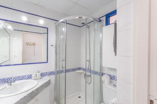 een witte badkamer met douche en wastafel bij Brisas Canarias in Puerto Rico de Gran Canaria