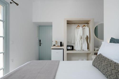 a white bedroom with a bed and a closet at Naxos Tower in Naxos Chora