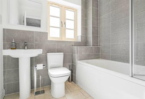 a bathroom with a toilet and a sink and a bath tub at House Launton Village - close to Tythe Barn, Blenheim Palace & Bicester Shopping in Launton