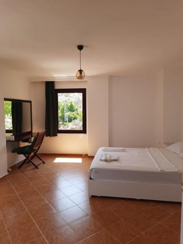 a bedroom with a bed and a window and a television at Villa ZEYNO in Kaş