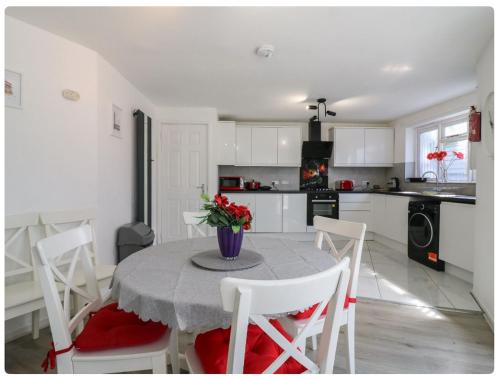 a kitchen with a table with a vase of flowers on it at The Alex in London
