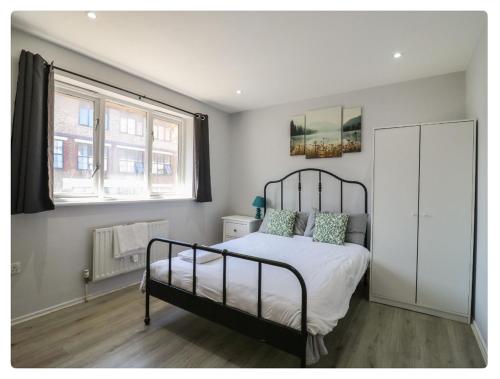a bedroom with a bed and a large window at The Alex in London