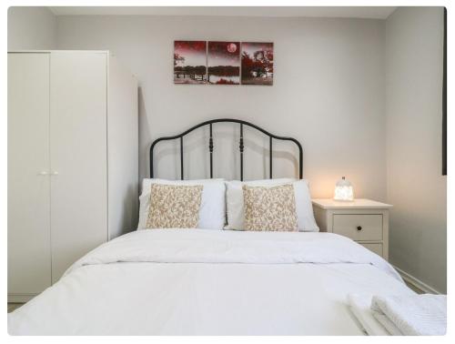 a bedroom with a white bed with a metal headboard at The Alex in London