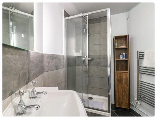 a bathroom with a sink and a shower at The Alex in London