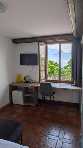 a room with a desk and a window and a chair at Castle view by MK in Montreux