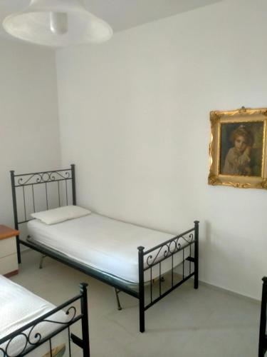 a bedroom with two beds and a painting on the wall at Cologna Beach in LʼAnnunziata
