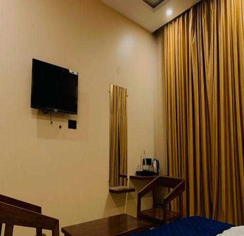 a hotel room with a television and curtains at AuroBESHA in Puducherry Airpoert