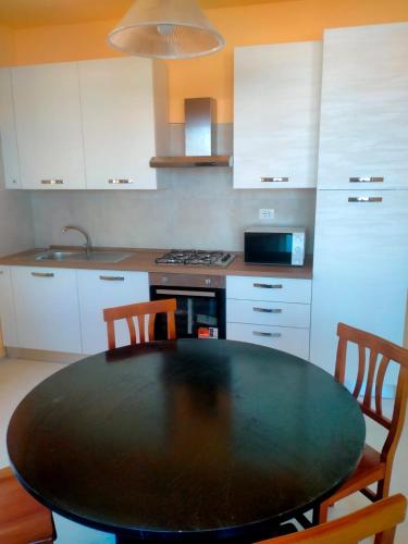 a kitchen with a black table and two chairs at Cologna Beach in LʼAnnunziata