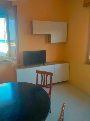 a kitchen with a table and a chair in a room at Cologna Beach in LʼAnnunziata