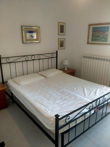 a bedroom with a large bed with white sheets at Cologna Beach in LʼAnnunziata