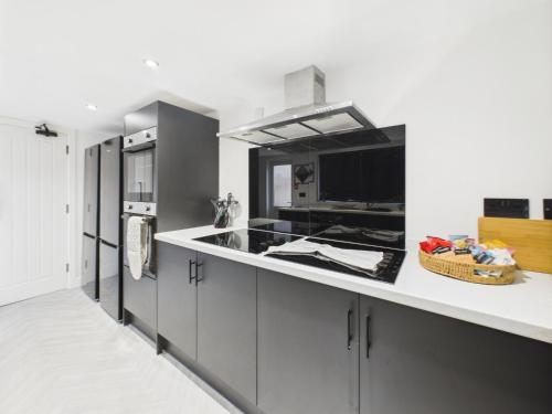 una cocina con encimeras blancas y armarios grises en Hartington, en Stockton-on-Tees