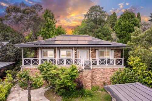a brick house with solar panels on the roof at Whisper on the Falls in Wentworth Falls
