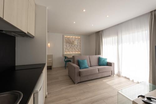 a living room with a couch and a chair at Hotel Club Es Talaial in Cala d´Or