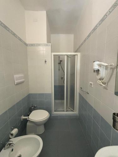 a bathroom with a shower and a toilet and a sink at Hotel La Vela in Isole Tremiti