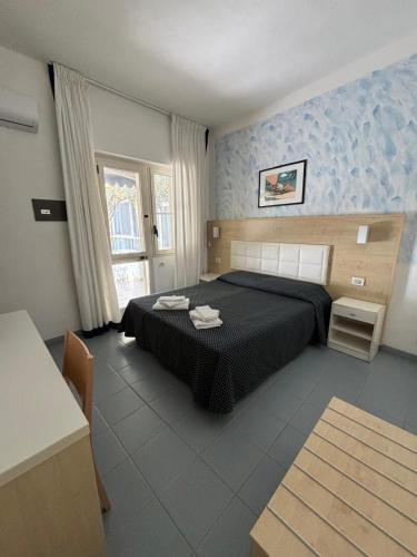 a bedroom with a black bed in a room at Hotel La Vela in Isole Tremiti