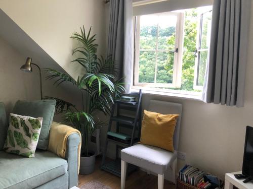 a living room with a couch and a chair and a window at The Nest Danehill in Haywards Heath