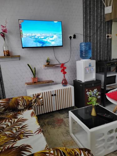 a living room with a couch and a tv on the wall at ALMASI - Utawala in Nairobi