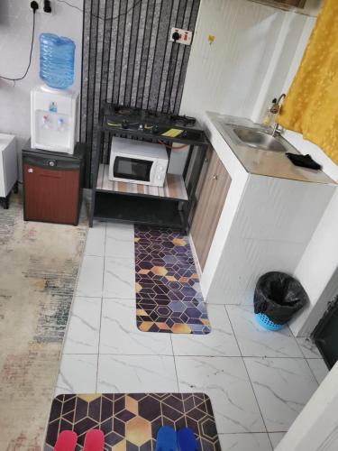 a small kitchen with a sink and a microwave at ALMASI - Utawala in Nairobi