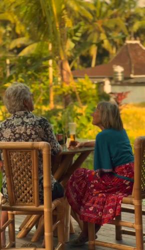 two older women sitting at a table in chairs at Green Lander Ubud in Ubud
