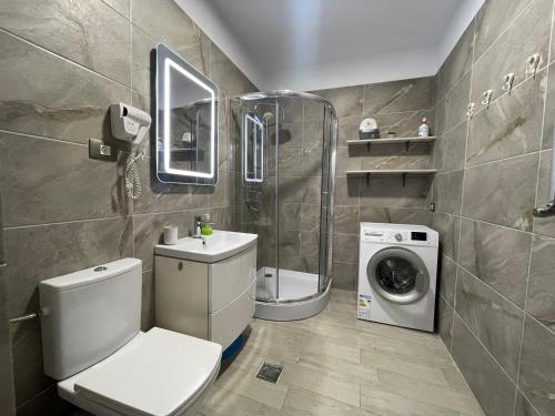 a bathroom with a toilet and a washing machine at Allezzi Resort Mamaia Nord D 13 in Mamaia