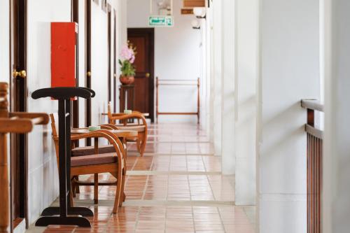 a corridor with chairs and a table in a building at Rimping Village in Chiang Mai