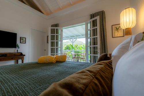 a bedroom with a bed with a couch and a window at 1493 lodge de charme le NINA in St Barthelemy